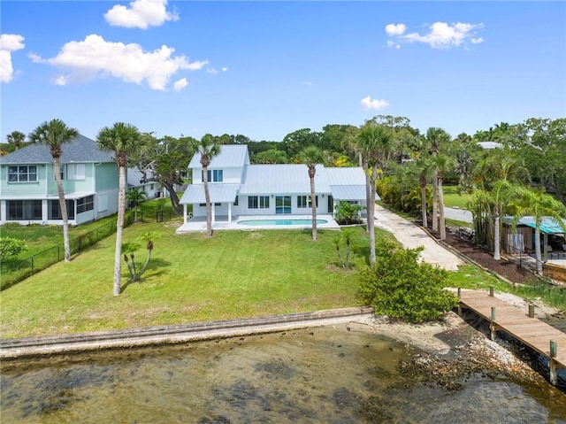 9670 Riverview Dr, Micco, FL 32976 - view of front of home featuring a water view, a metal roof, an outdoor pool, and driveway