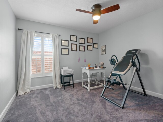 office space featuring dark carpet and ceiling fan