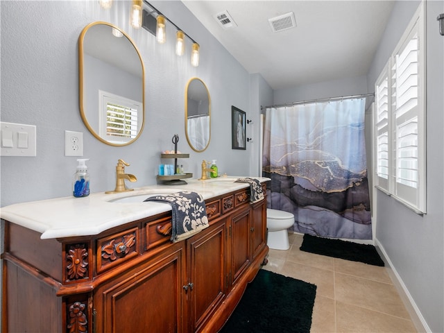 bathroom featuring vanity, tile patterned floors, a healthy amount of sunlight, and toilet