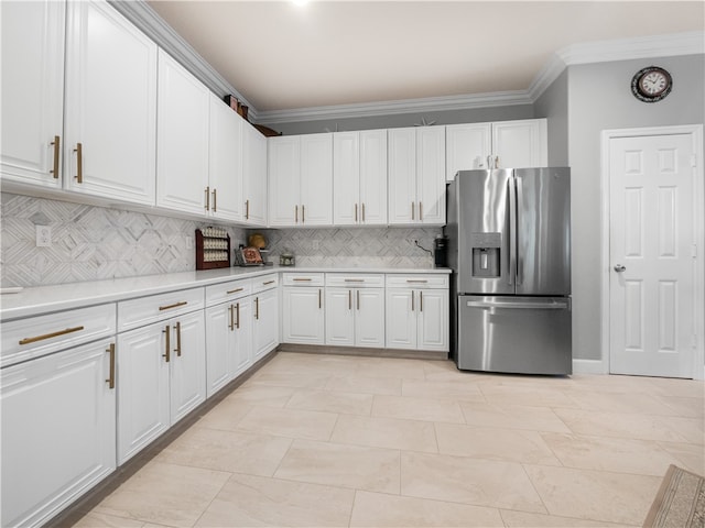 kitchen with light tile patterned flooring, white cabinetry, ornamental molding, backsplash, and stainless steel fridge