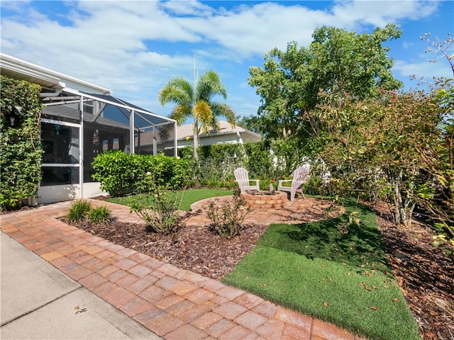 view of yard featuring glass enclosure and a patio area