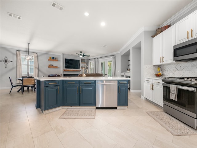 kitchen with plenty of natural light, blue cabinetry, white cabinets, and stainless steel appliances