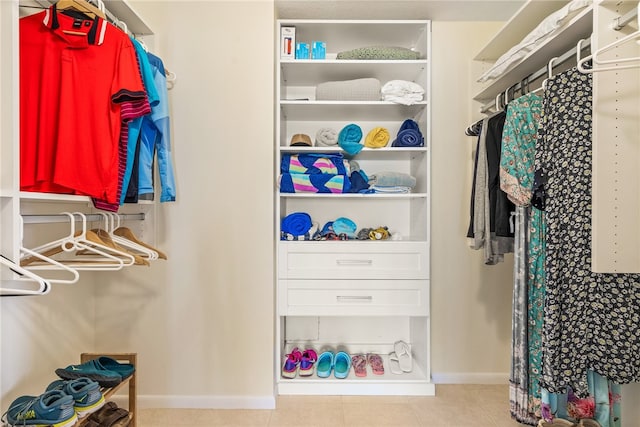 spacious closet with light tile patterned floors