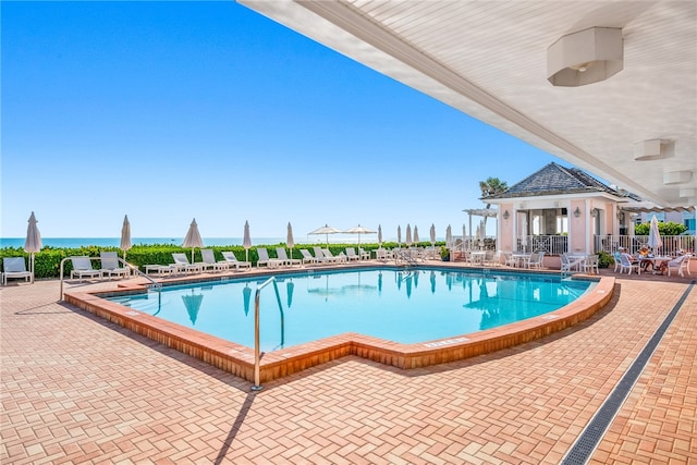 view of pool with a patio and a water view