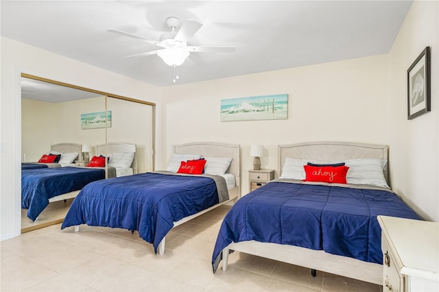 bedroom featuring a closet, light tile patterned floors, and ceiling fan