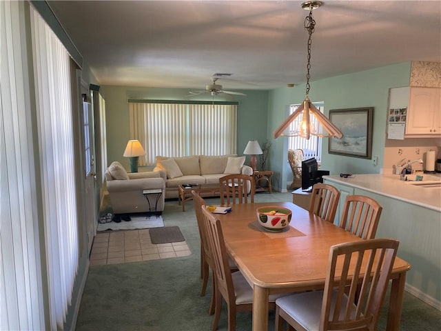 dining space featuring carpet flooring, ceiling fan, and tile patterned flooring