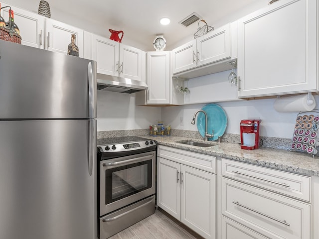 kitchen with appliances with stainless steel finishes, sink, light hardwood / wood-style floors, and white cabinets