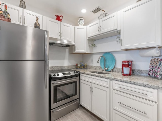 2800 Indian River Blvd Unit M7, Vero Beach, FL 32960 - kitchen with stainless steel appliances, under cabinet range hood, a sink, white cabinets, and recessed lighting