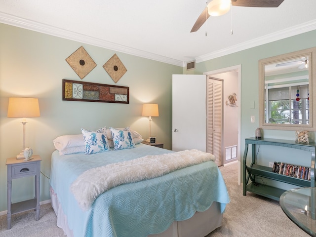 carpeted bedroom with ceiling fan, a closet, and crown molding