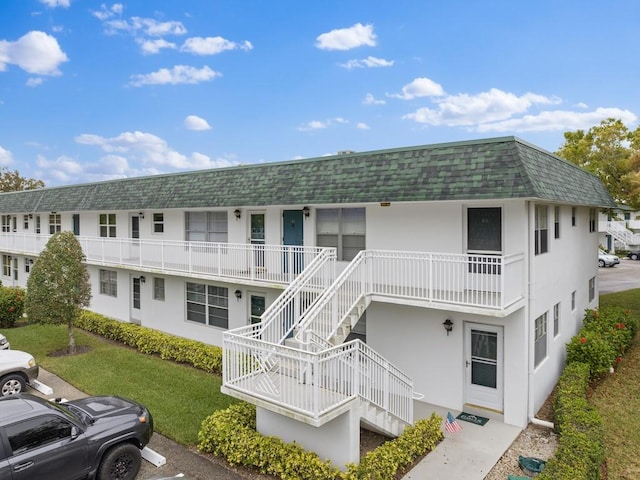 2800 Indian River Blvd Unit M7, Vero Beach, FL 32960 - view of building exterior featuring stairs and uncovered parking