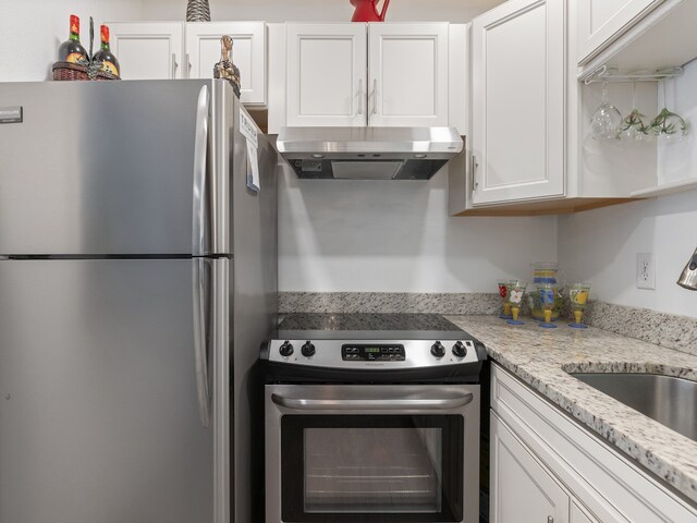 kitchen featuring light stone countertops, white cabinets, sink, and stainless steel appliances