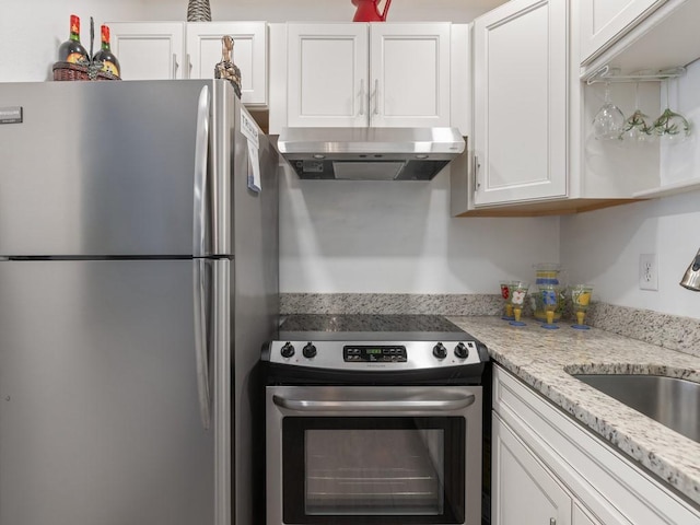 2800 Indian River Blvd Unit M7, Vero Beach, FL 32960 - kitchen with stainless steel appliances, under cabinet range hood, white cabinetry, a sink, and light stone counters