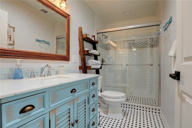 bathroom with tile patterned flooring, vanity, toilet, and an enclosed shower