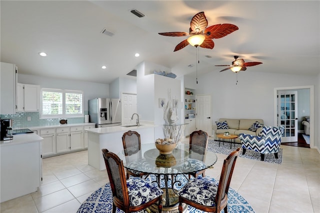 dining area with ceiling fan, sink, light tile patterned flooring, and lofted ceiling