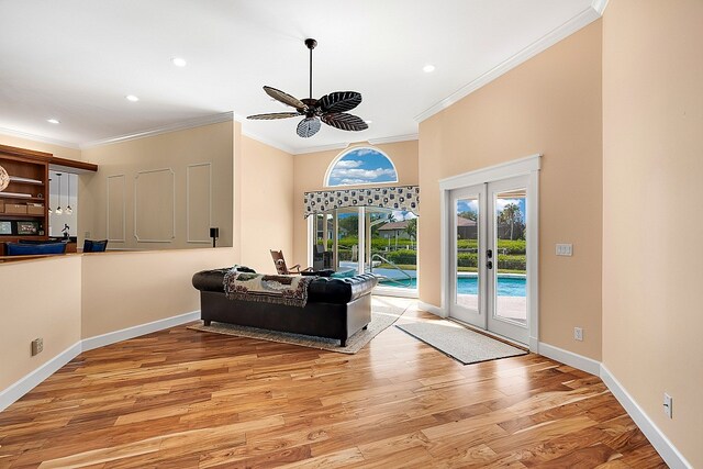 living room with french doors, light wood-type flooring, ceiling fan, and crown molding