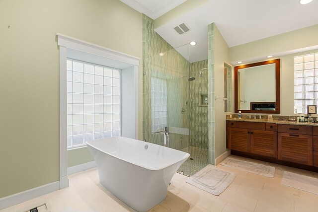 bathroom featuring tile patterned flooring, vanity, crown molding, and plus walk in shower