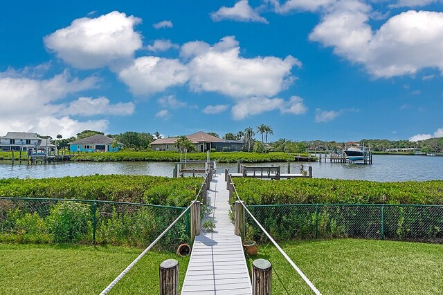 view of dock featuring a water view and a lawn