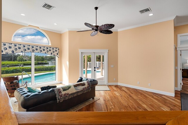 living room featuring light hardwood / wood-style floors, ceiling fan, and crown molding