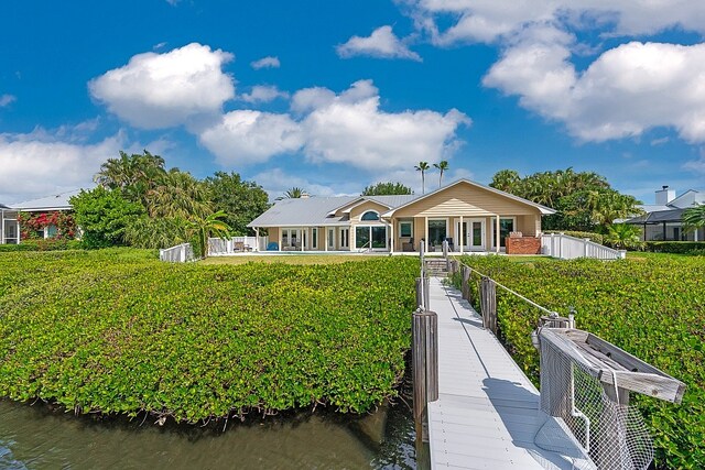 rear view of property featuring a water view and a yard