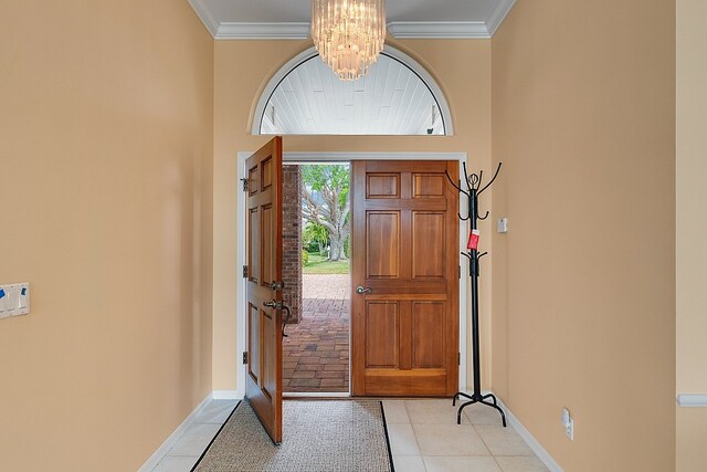 foyer entrance featuring a towering ceiling, light tile patterned floors, and crown molding