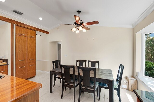 tiled dining area with ceiling fan, crown molding, and lofted ceiling