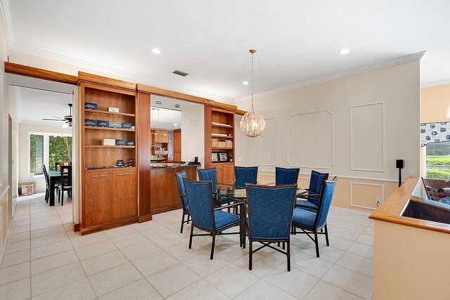 tiled dining space with a wealth of natural light, sink, ceiling fan, and crown molding