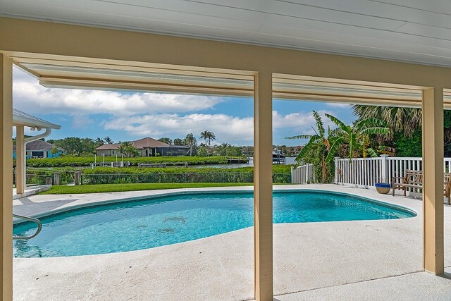 view of swimming pool with a patio and a water view