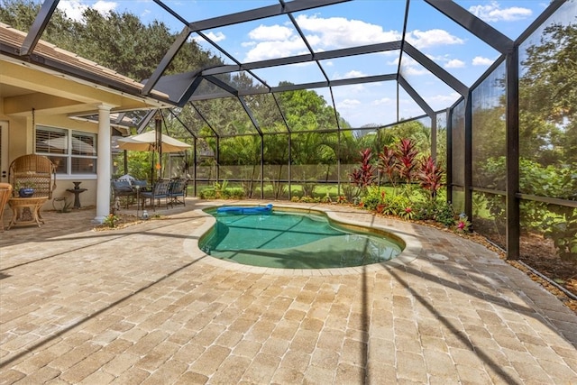 view of swimming pool featuring a lanai and a patio