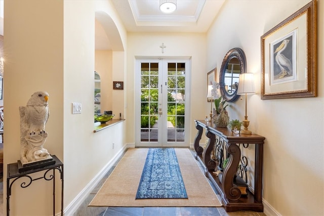 doorway to outside featuring a tray ceiling, french doors, and crown molding