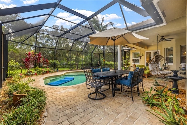 view of swimming pool featuring glass enclosure, a patio, and ceiling fan