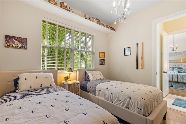 bedroom with hardwood / wood-style floors and a notable chandelier