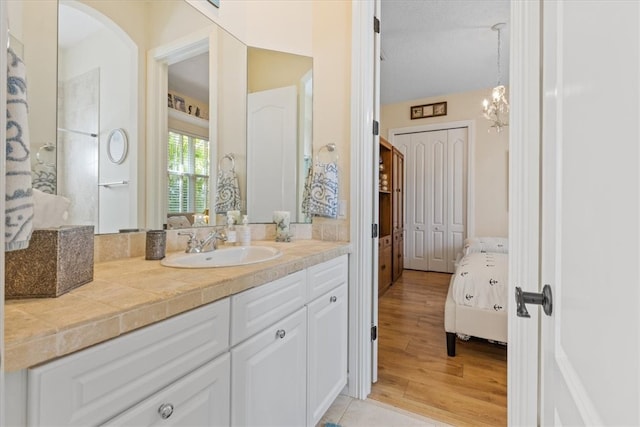 bathroom featuring vanity, a chandelier, and hardwood / wood-style flooring