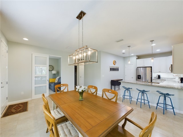 dining space featuring sink and light tile patterned floors