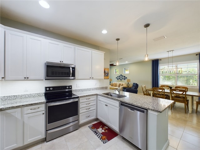 kitchen with stainless steel appliances, white cabinetry, hanging light fixtures, sink, and kitchen peninsula