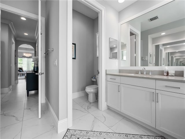 bathroom featuring vanity, toilet, and ornamental molding