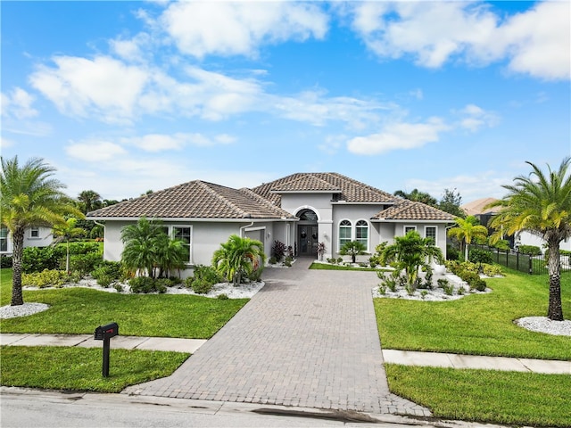 mediterranean / spanish home featuring a front yard