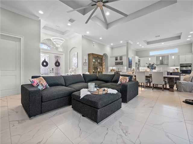 living room featuring french doors, crown molding, a high ceiling, a tray ceiling, and ceiling fan