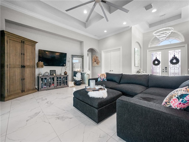 living room with ceiling fan, french doors, ornamental molding, and a towering ceiling