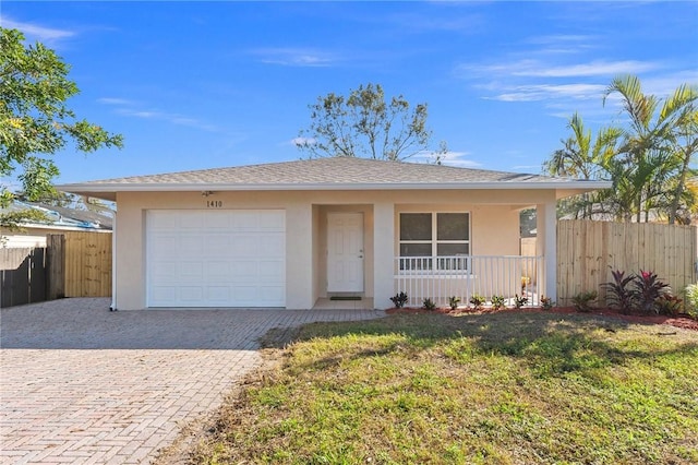 single story home featuring a garage, covered porch, and a front lawn