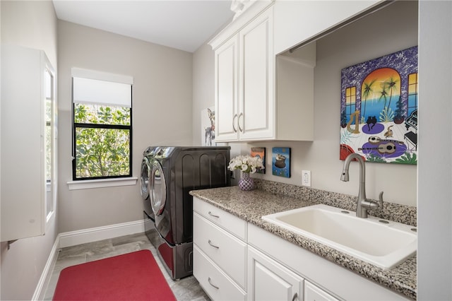 1205 Isla Verde Sq, Vero Beach, FL 32963 - washroom featuring a sink, baseboards, cabinet space, and separate washer and dryer