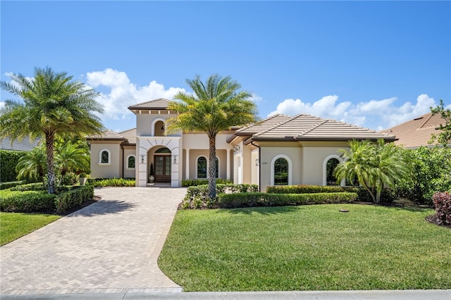 1205 Isla Verde Sq, Vero Beach, FL 32963 - mediterranean / spanish-style house featuring stucco siding, decorative driveway, a front lawn, and a tile roof