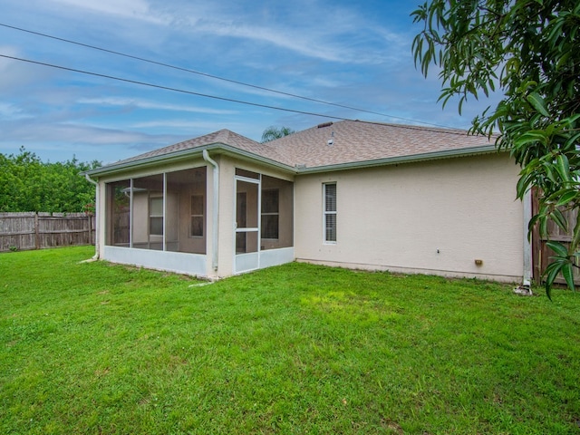 back of house featuring a yard and a sunroom