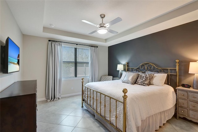 tiled bedroom with a raised ceiling and ceiling fan