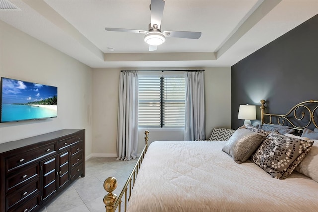 bedroom featuring light tile patterned floors, a raised ceiling, and ceiling fan