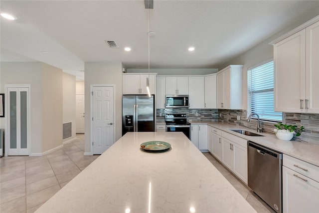 kitchen featuring stainless steel appliances, white cabinetry, and sink