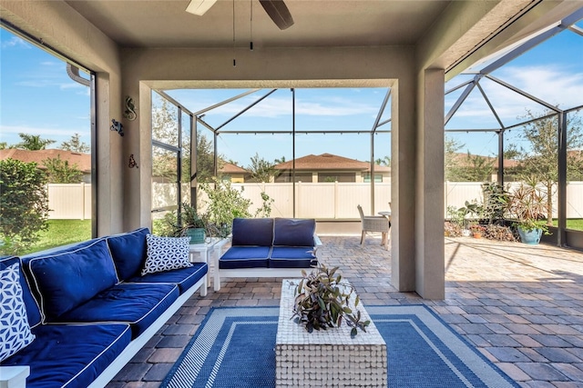 exterior space featuring outdoor lounge area, glass enclosure, and ceiling fan