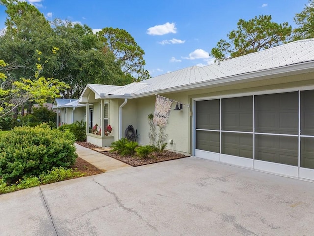 view of front of house featuring stucco siding, driveway, and a garage