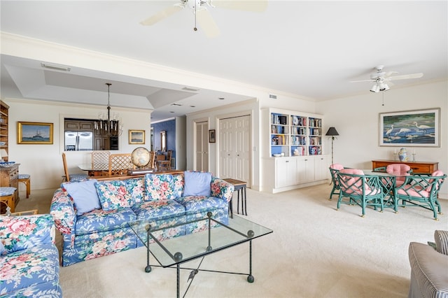 living room with light carpet, ceiling fan with notable chandelier, and ornamental molding