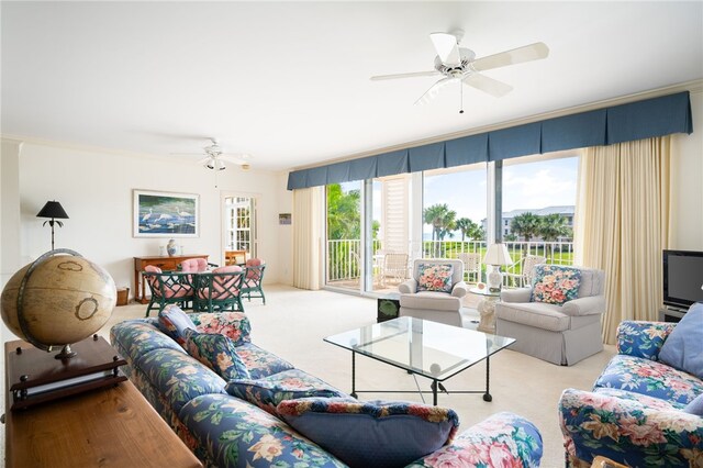 living room featuring ceiling fan, crown molding, and light carpet