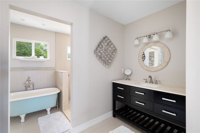 bathroom featuring tile patterned floors, a tub, and vanity